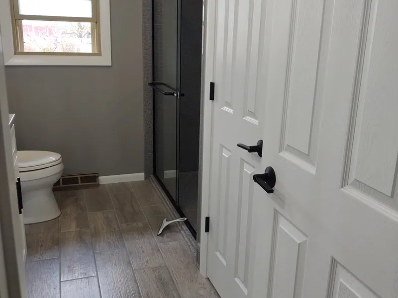 Gray wood-look plank tile flooring in a finished Excel bathroom remodel