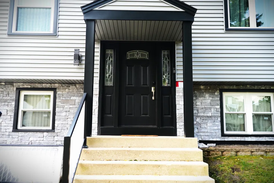 A new black entry door with decorative-glass sidelites on a Chicagoland south-suburb home — an Excel install