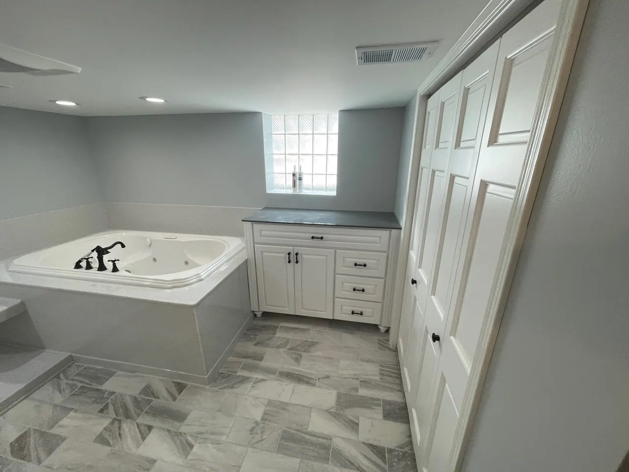 Full bathroom remodel with a corner jetted tub and white cabinetry, Chicagoland