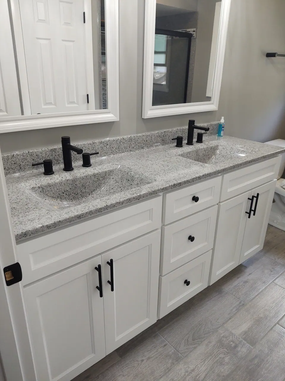 White shaker double vanity with a speckled-granite top and matte-black fixtures, Chicagoland