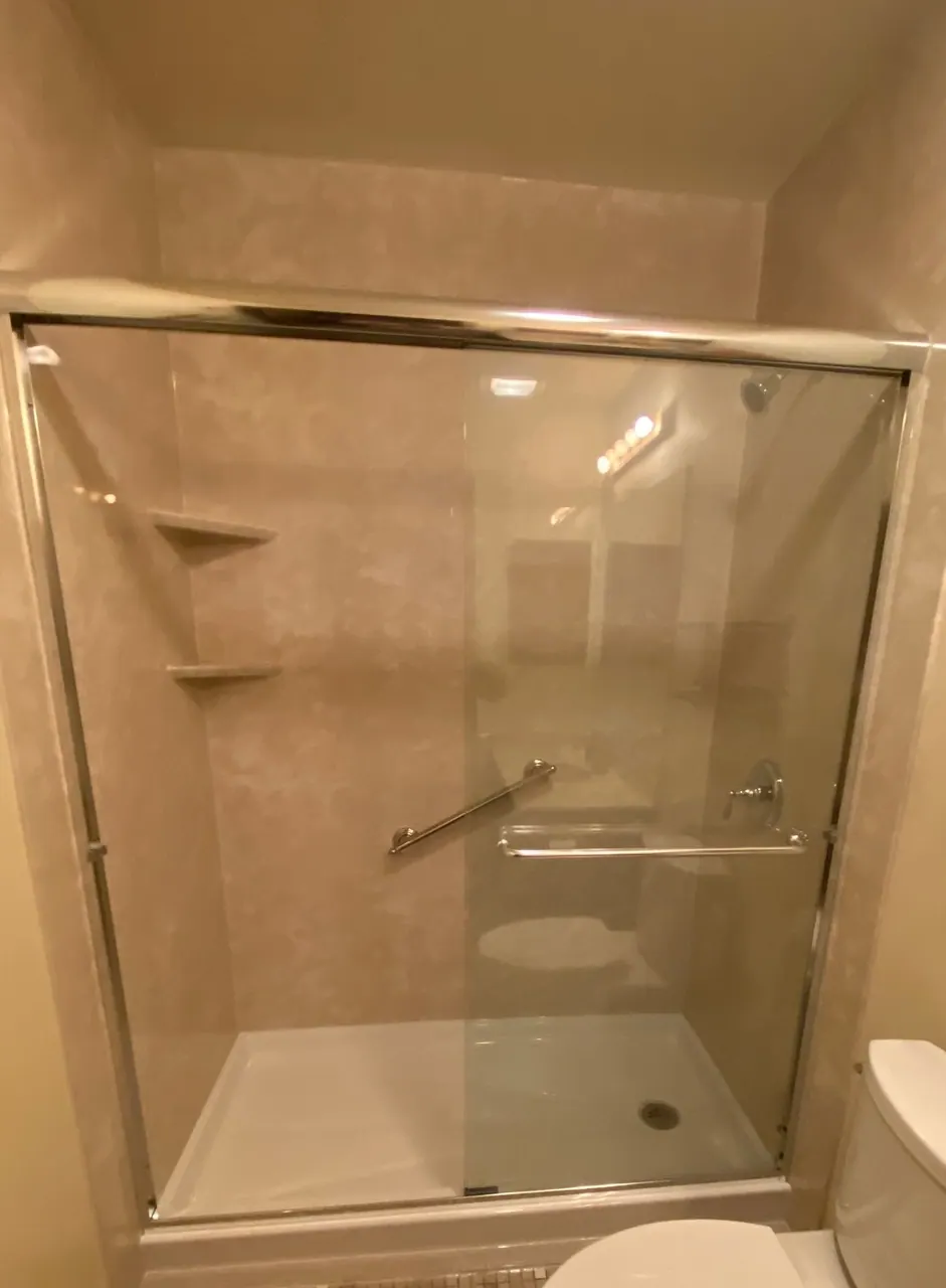 Tub-to-shower conversion with sliding glass doors and a grab bar, an Excel install