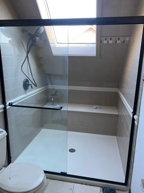 New walk-in shower with a glass enclosure under a skylight, an Excel install