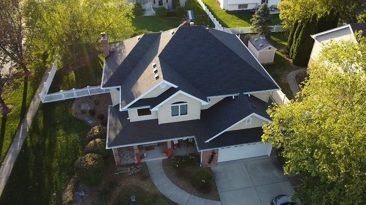 Aerial of a completed architectural-shingle roof at golden hour, Chicagoland