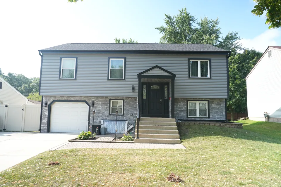 A two-story home with new gray lap siding and a stone-accented lower level, Chicagoland south suburbs — an Excel install