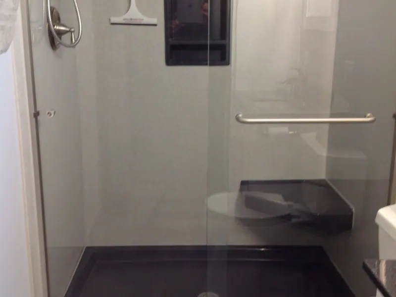 Finished walk-in shower with gray solid-surface walls, a corner seat, and a grab bar, an Excel install in the south suburbs