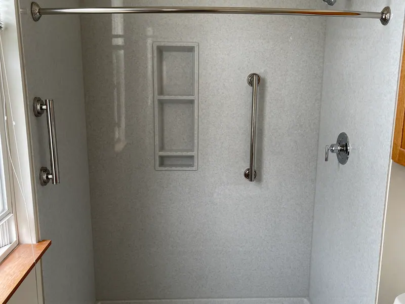 Finished walk-in shower with gray solid-surface walls, grab bars, and a handheld sprayer, an Excel install in the south suburbs